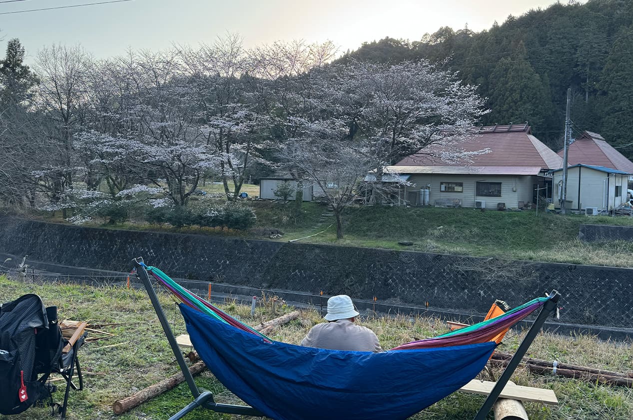 対岸の桜と川を望むハンモック